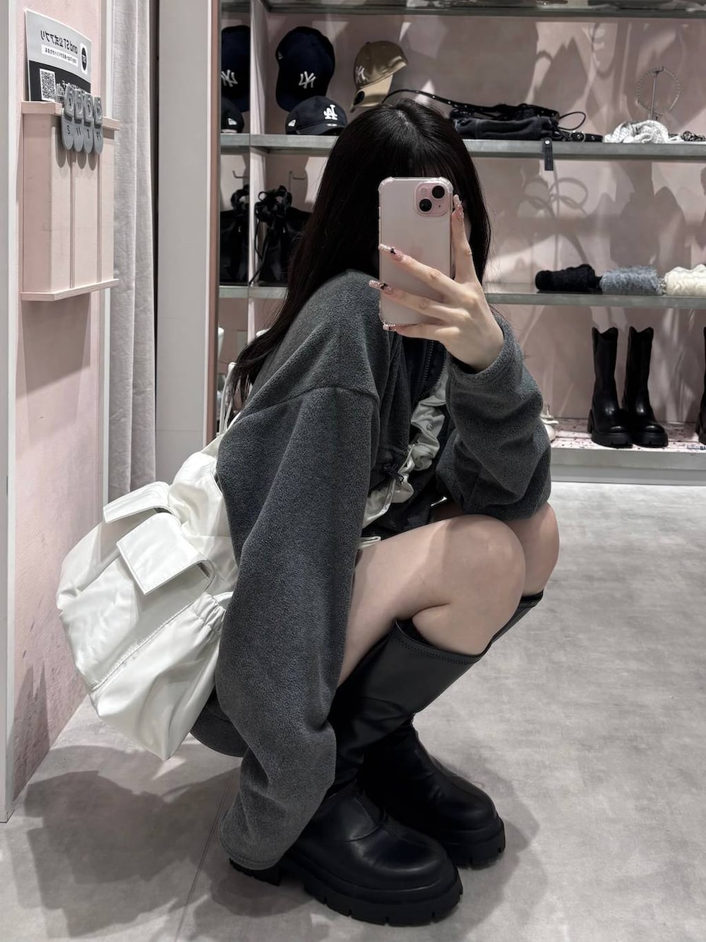 ブラック系のブーツ、グレー系のワンピース、ホワイト系のショルダーバッグを着用したレディースの冬コーディネートの6枚目の写真