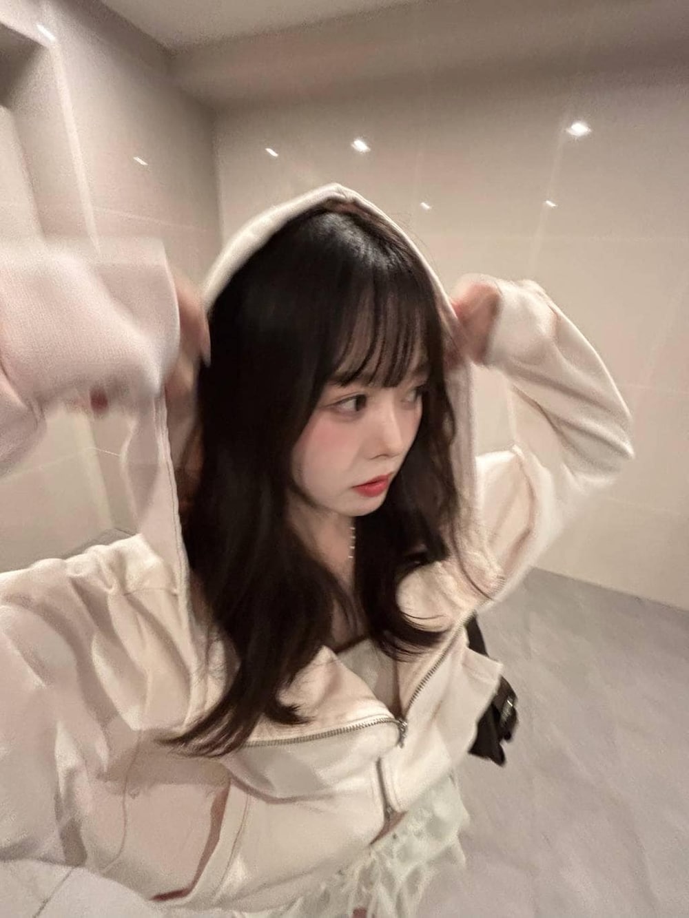 ホワイト系のキャミソール、ピンク系のパーカーを着用したレディースの春コーディネートの4枚目の写真