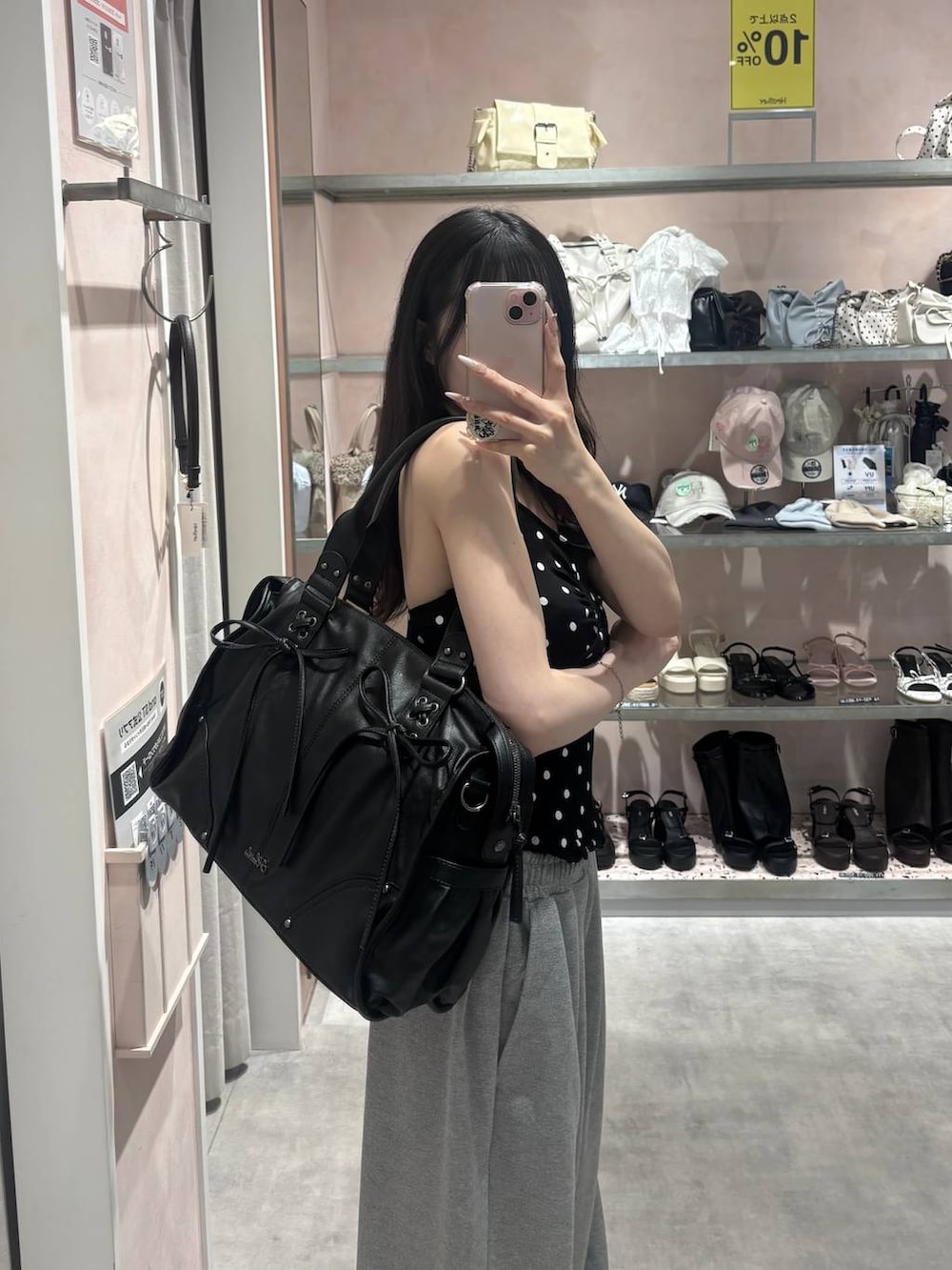 ブラック系のトートバッグ、ブラック系のその他トップス、グレー系のスウェットパンツを着用したレディースの夏コーディネートの7枚目の写真