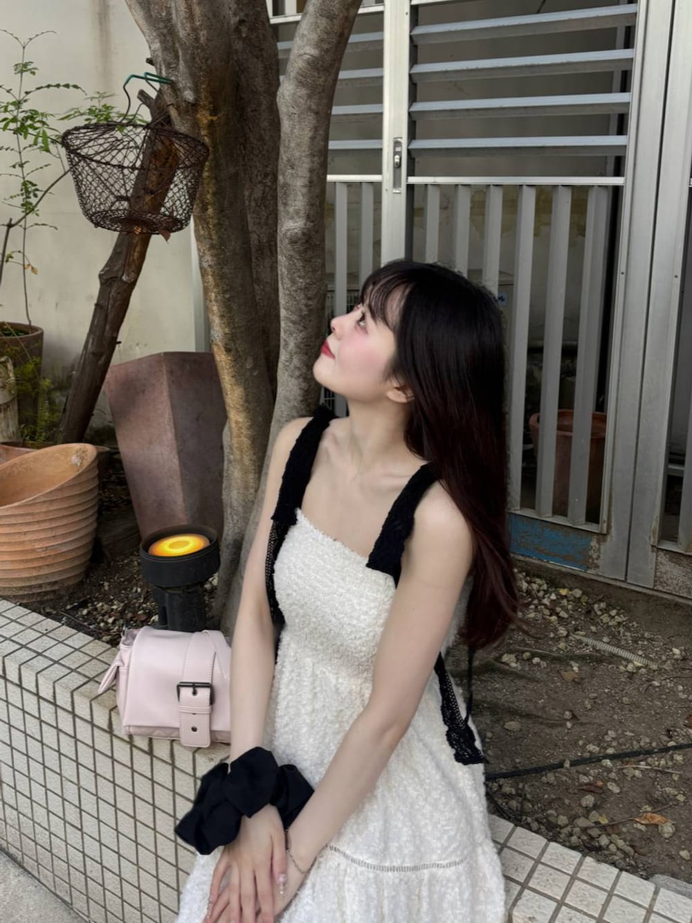 ブラック系のパンプス、ホワイト系のチューブトップ、ホワイト系のワンピースを着用したレディースの春コーディネートの3枚目の写真