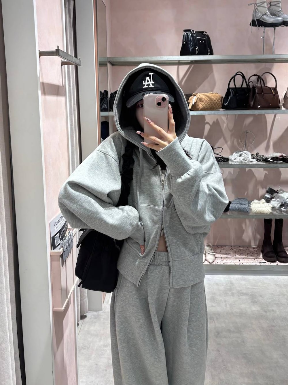 ブラック系のショルダーバッグ、グレー系のパーカー、グレー系のスウェットパンツを着用したレディースの冬コーディネートの8枚目の写真