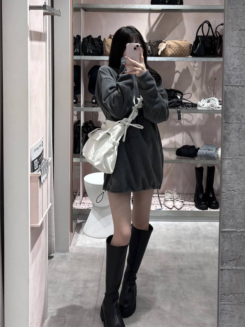 ブラック系のブーツ、グレー系のワンピース、ホワイト系のショルダーバッグを着用したレディースの冬コーディネートの2枚目の写真