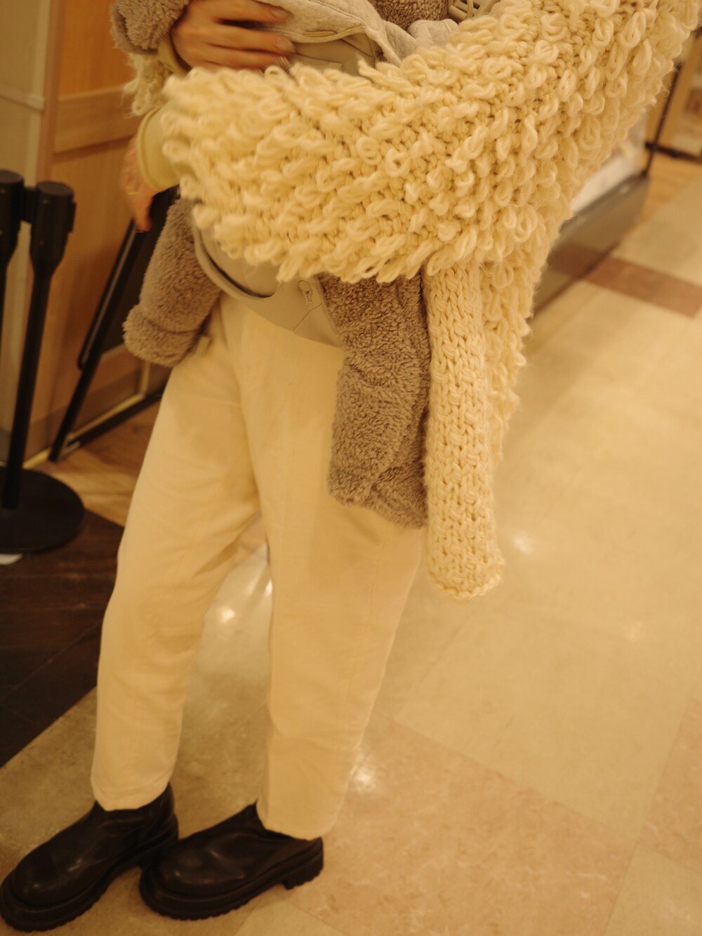 ホワイト系のその他パンツ、ブラック系のブーツ、その他のカーディガン/ボレロを着用したレディースの冬コーディネートの3枚目の写真