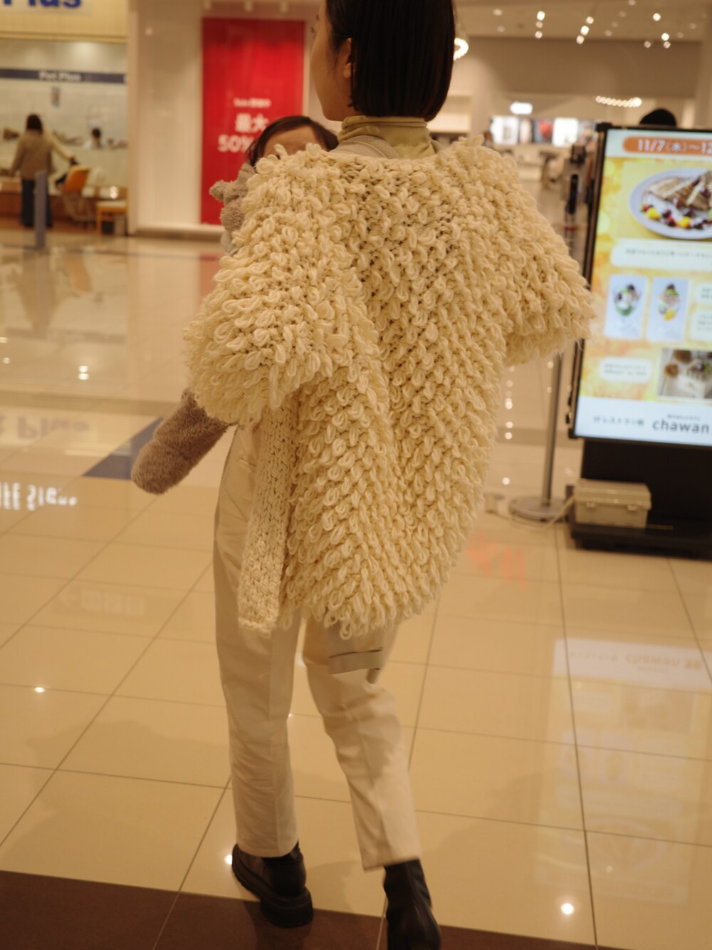 ホワイト系のその他パンツ、ブラック系のブーツ、その他のカーディガン/ボレロを着用したレディースの冬コーディネートの2枚目の写真