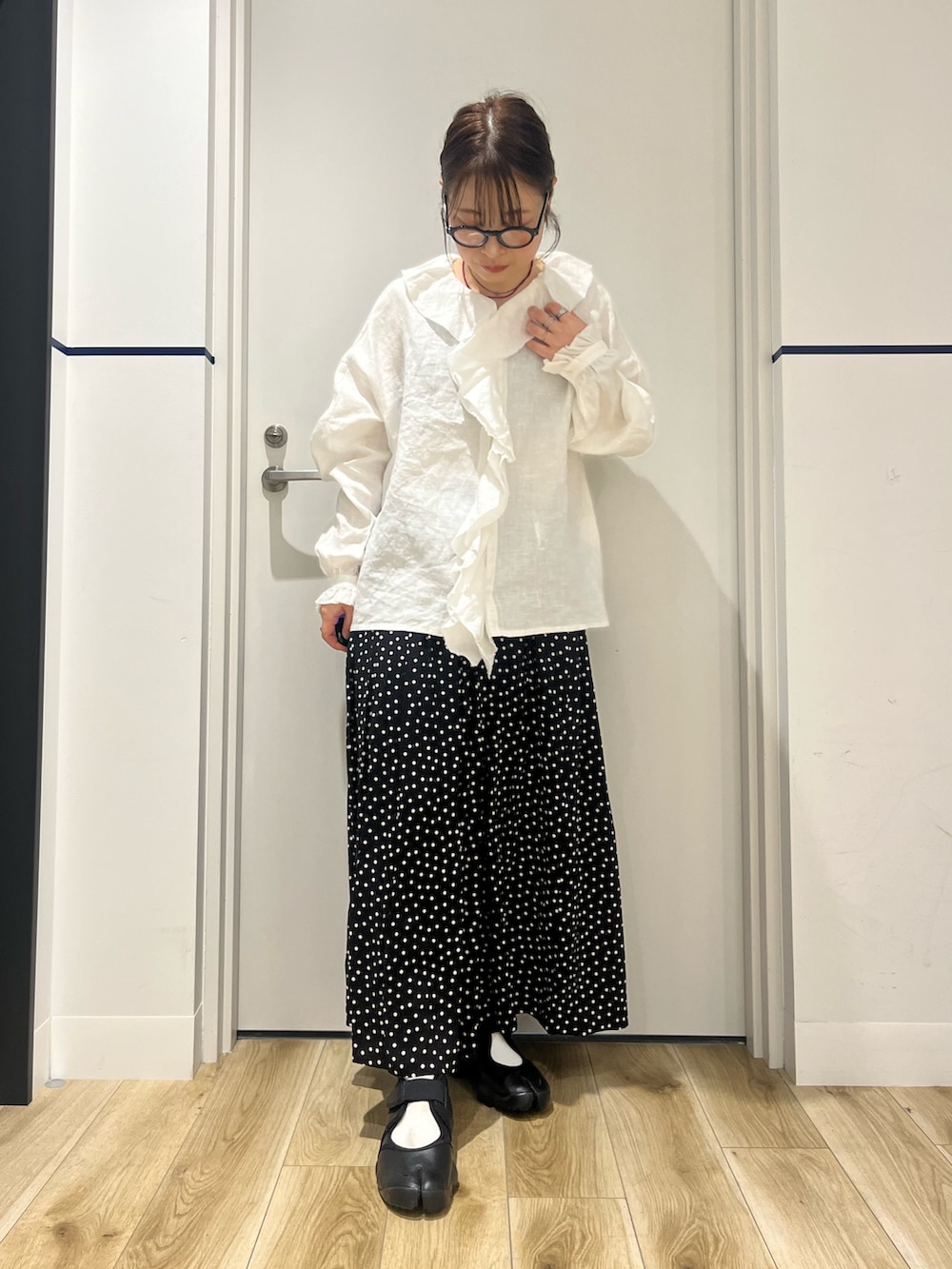 ブラック系のスニーカー、ブラック系のスカート、グレー系のカバーオールを着用したレディースの春コーディネートの4枚目の写真