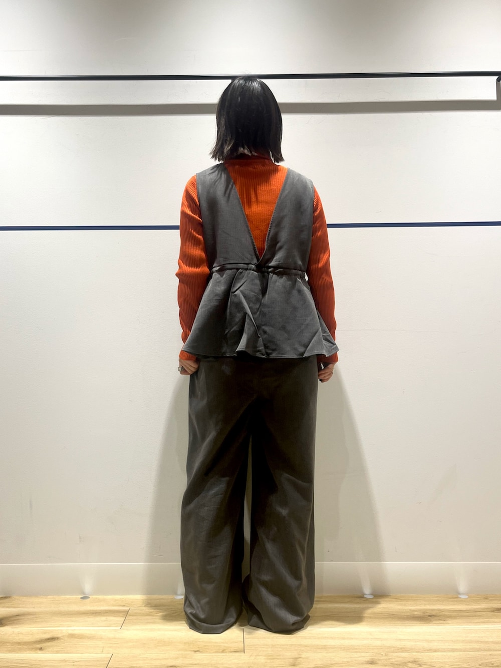 オレンジ系のニット/セーター、グレー系のその他パンツ、ホワイト系のショルダーバッグを着用したレディースの冬コーディネートの4枚目の写真