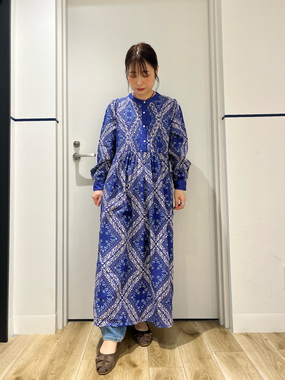 ブルー系のデニムパンツ、ブルー系のワンピース、ブラウン系のパンプスを着用したレディースの春コーディネートの4枚目の写真