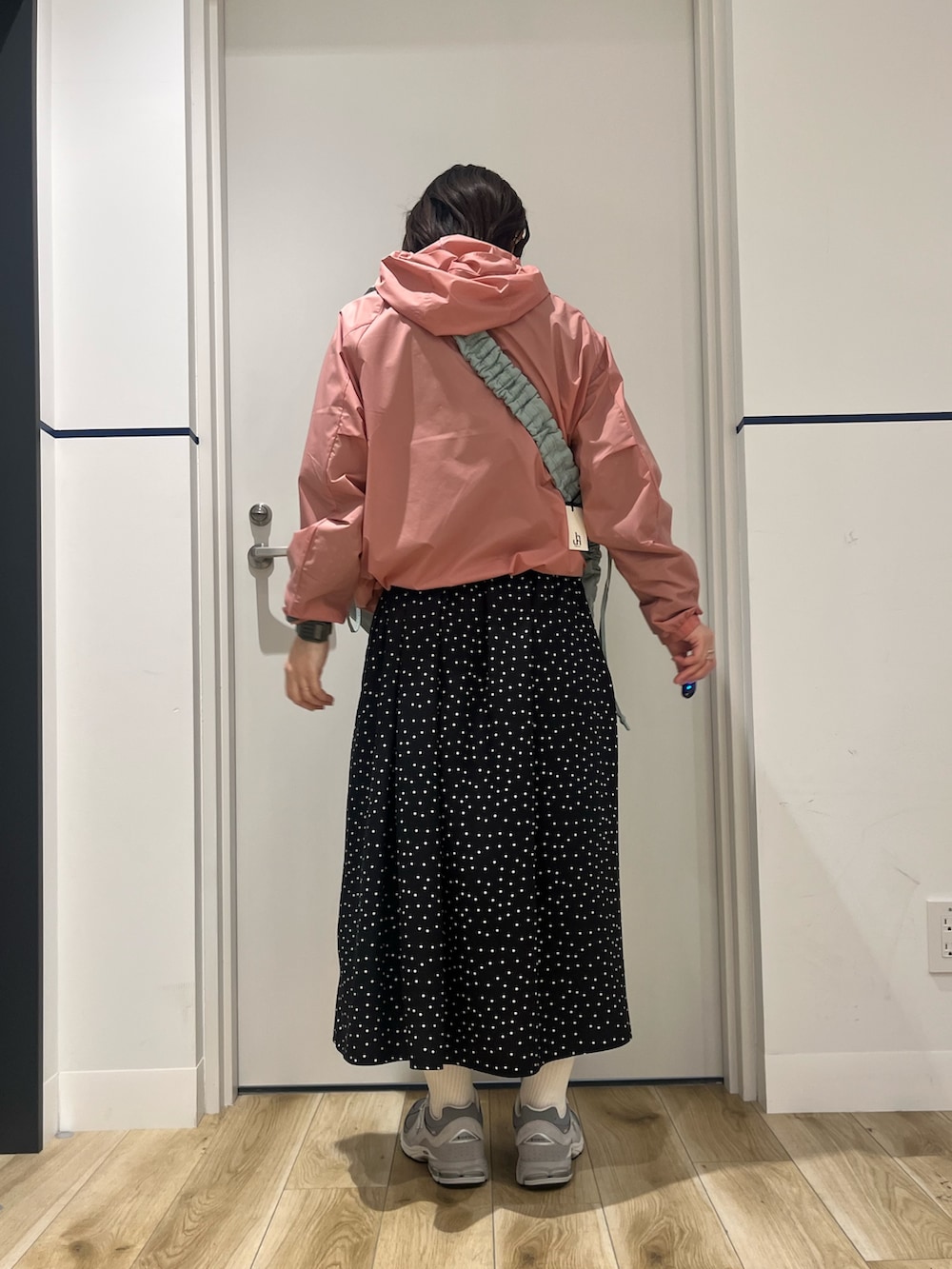 ベージュ系のスニーカー、ブラック系のワンピース、ピンク系のナイロンジャケットを着用したレディースの冬コーディネートの5枚目の写真