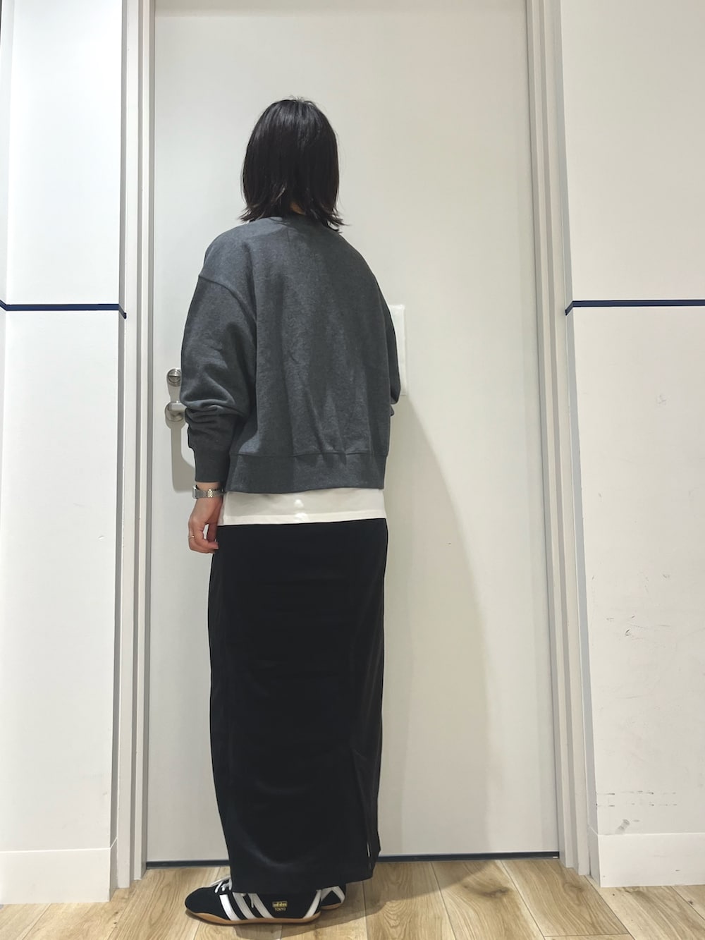 ブラック系のスニーカー、ブラック系のスカート、ホワイト系のTシャツ/カットソーを着用したレディースの秋コーディネートの3枚目の写真