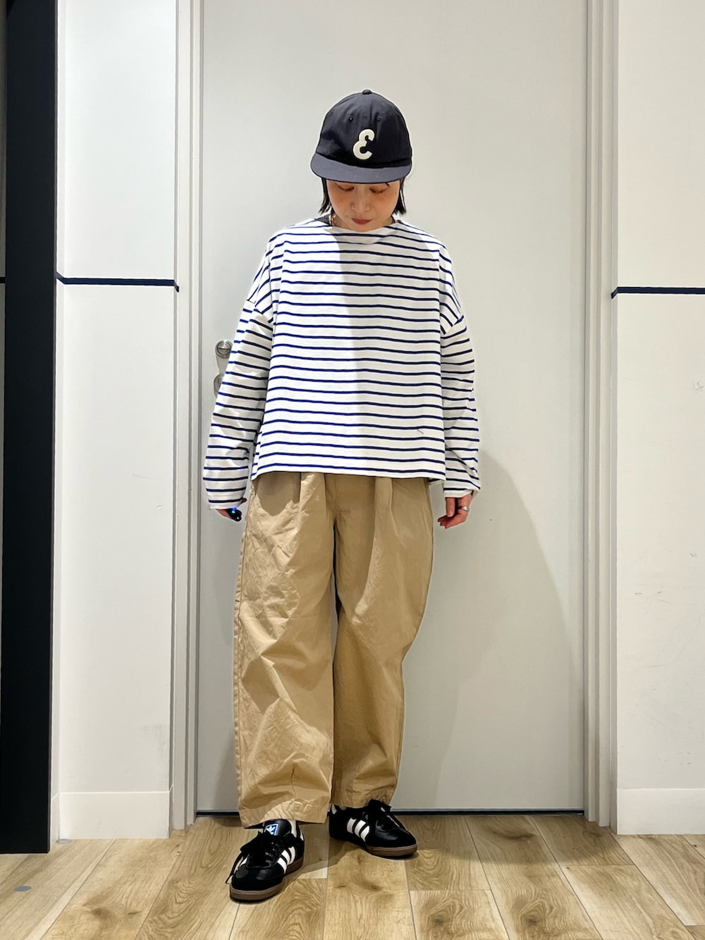 ブラック系のスニーカー、ブラック系のショルダーバッグ、ブルー系のTシャツ/カットソーを着用したレディースの冬コーディネートの2枚目の写真