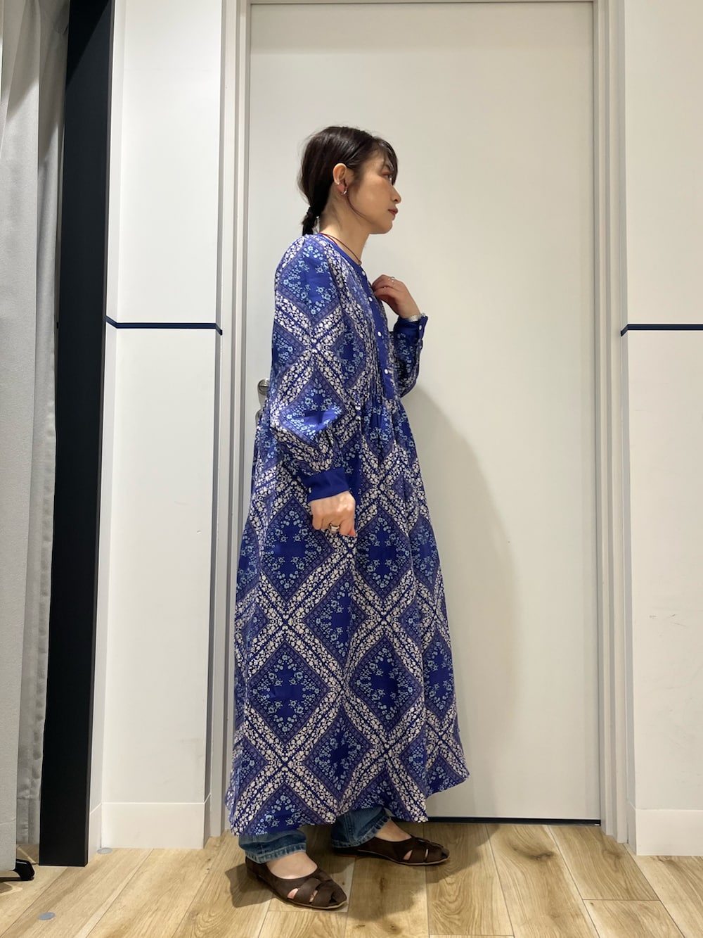 ブルー系のデニムパンツ、ブルー系のワンピース、ブラウン系のパンプスを着用したレディースの春コーディネートの5枚目の写真