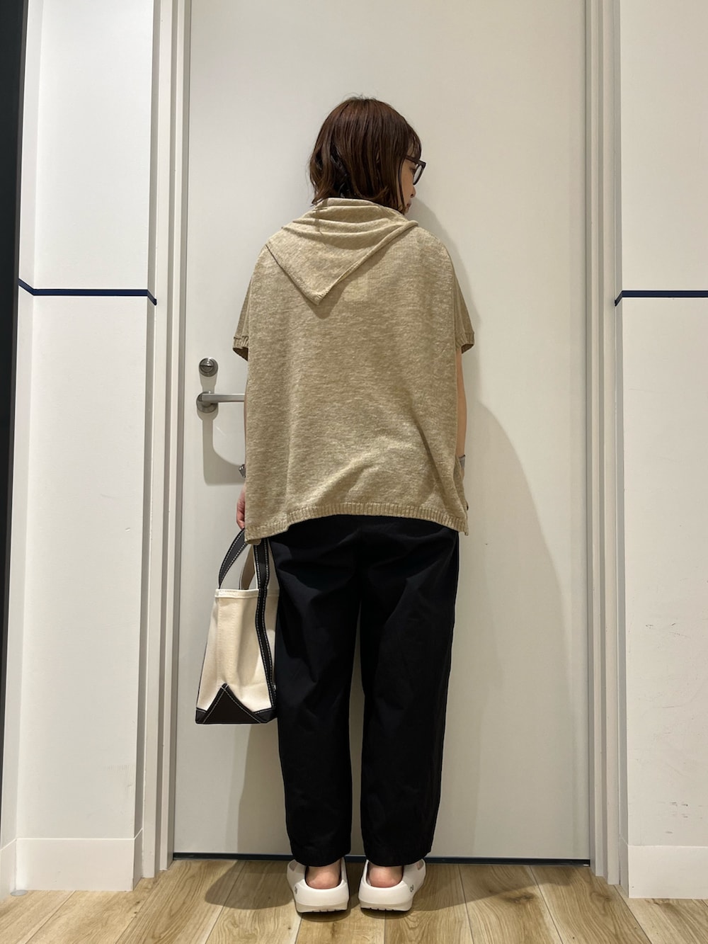 グレー系のトートバッグ、ホワイト系のサンダル、ブラック系のその他パンツを着用したレディースの春コーディネートの3枚目の写真
