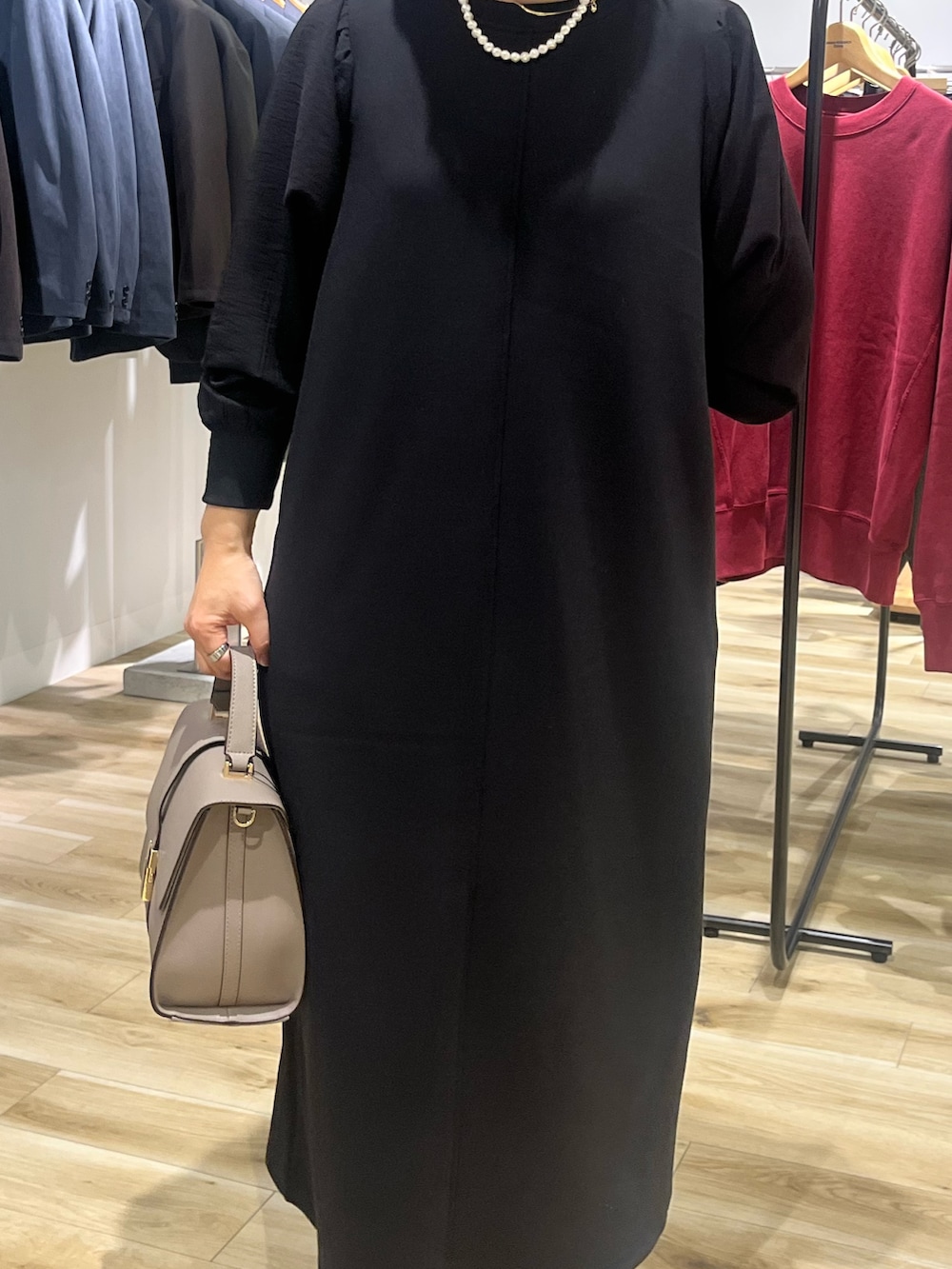 ブラック系のワンピース、グレー系のハンドバッグ、ブラック系のブーツを着用したレディースの秋コーディネートの5枚目の写真