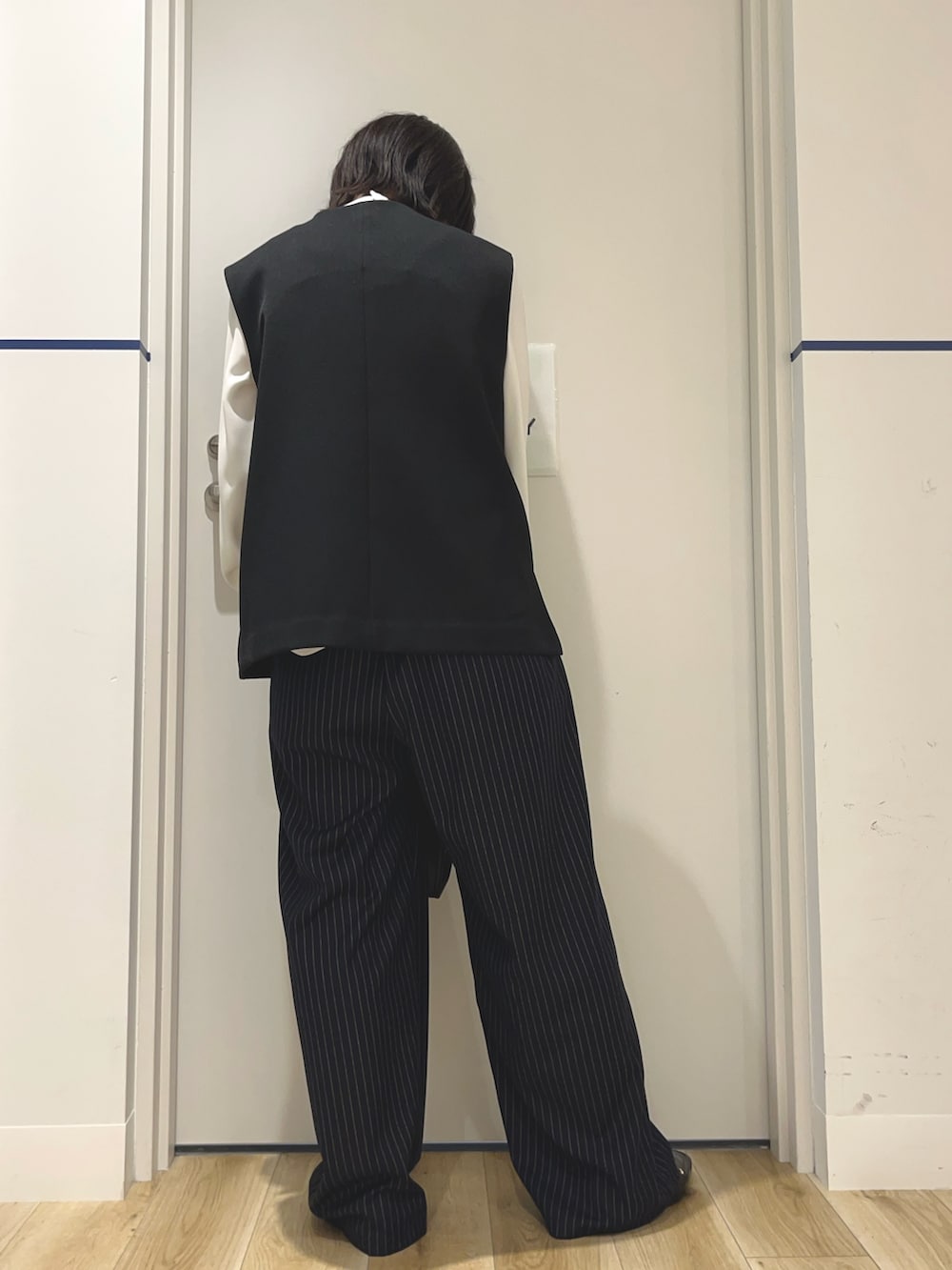 ホワイト系のシャツ/ブラウス、ブラック系のベスト、ブラック系のハンドバッグを着用したレディースの秋コーディネートの3枚目の写真