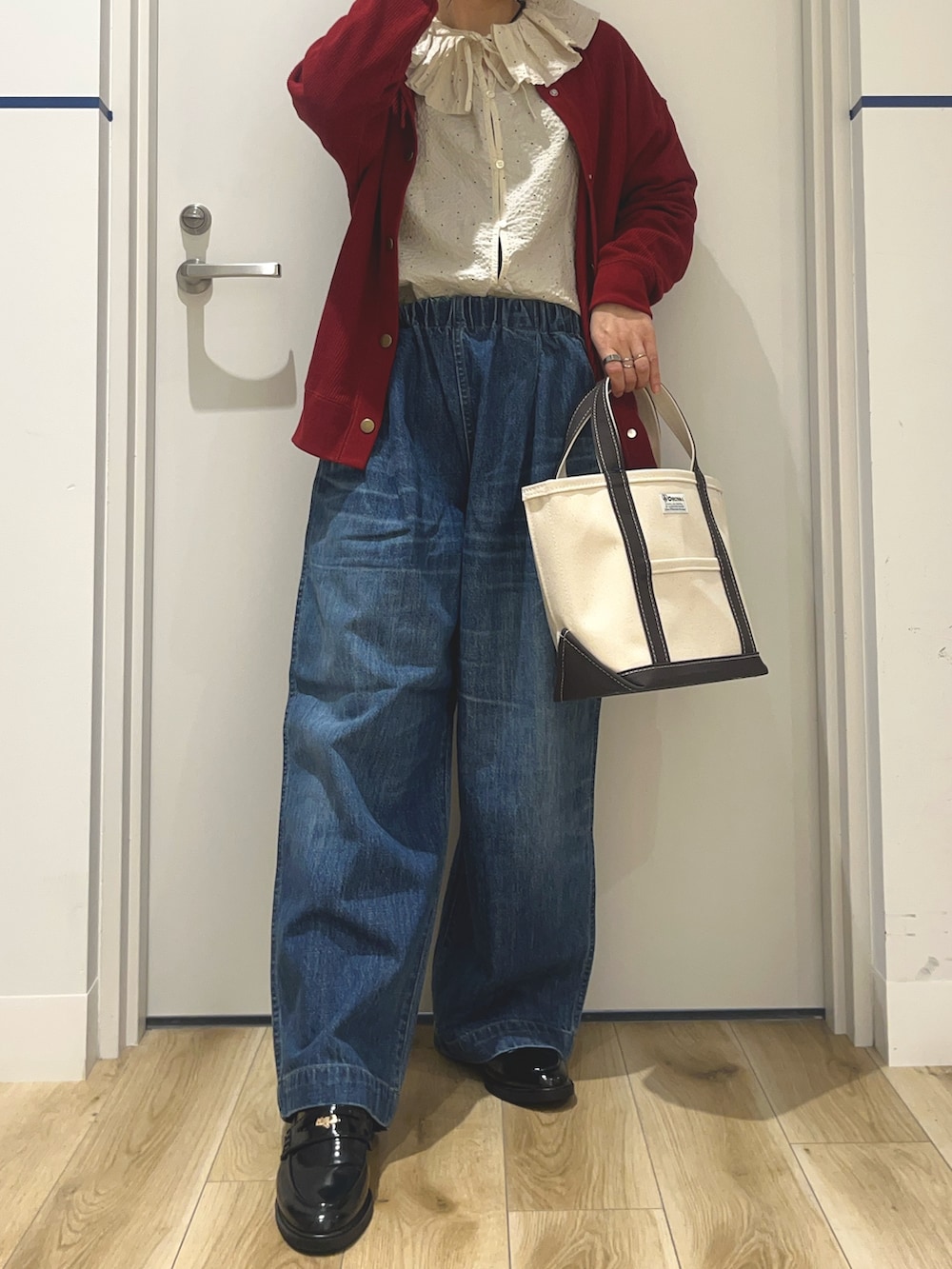 ブルー系のデニムパンツ、ブラック系のローファー、グレー系のトートバッグを着用したレディースの秋コーディネートの4枚目の写真