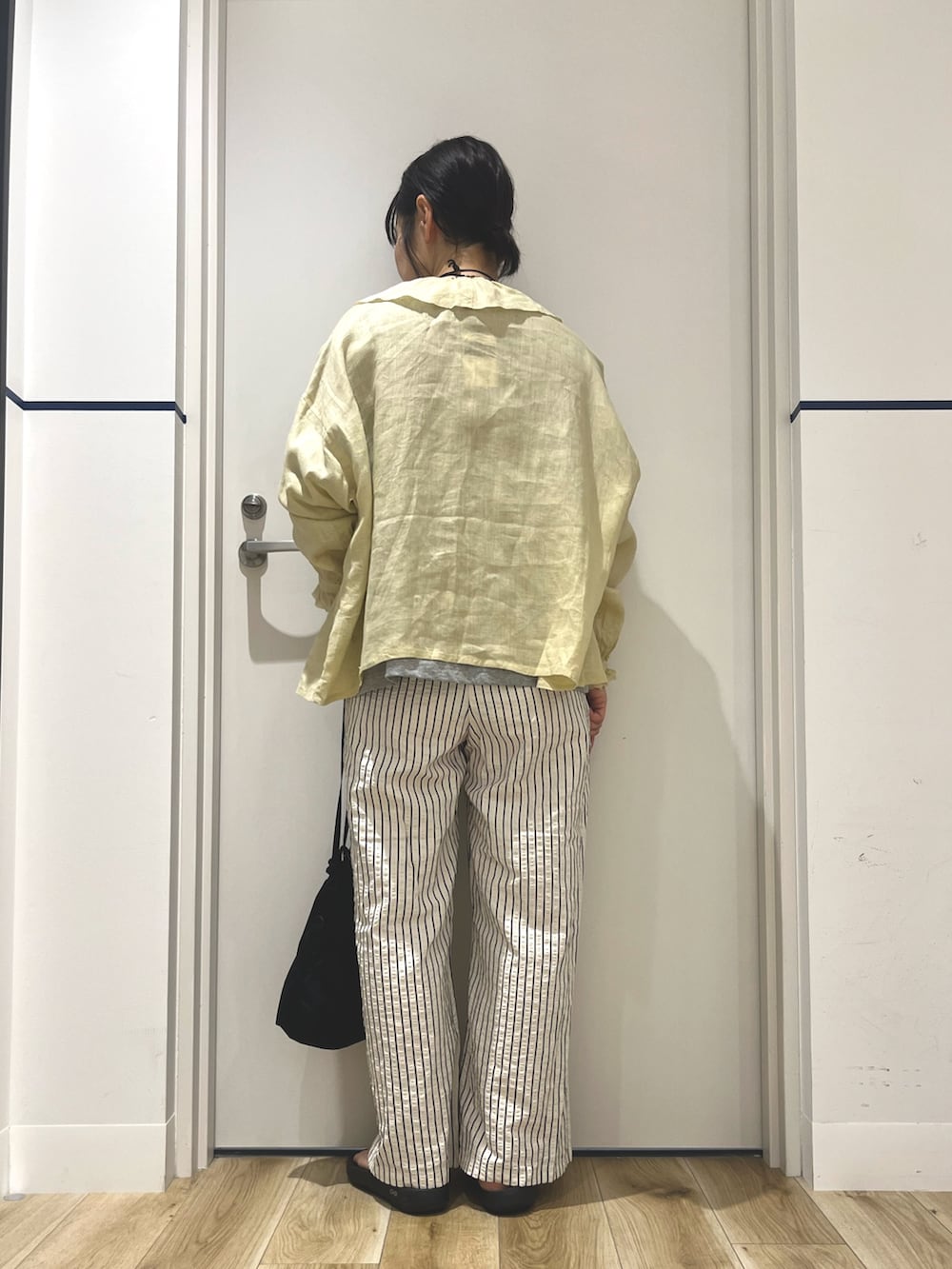 ブラック系のサンダル、ホワイト系のその他パンツ、ブラック系のバッグを着用したレディースの夏コーディネートの4枚目の写真