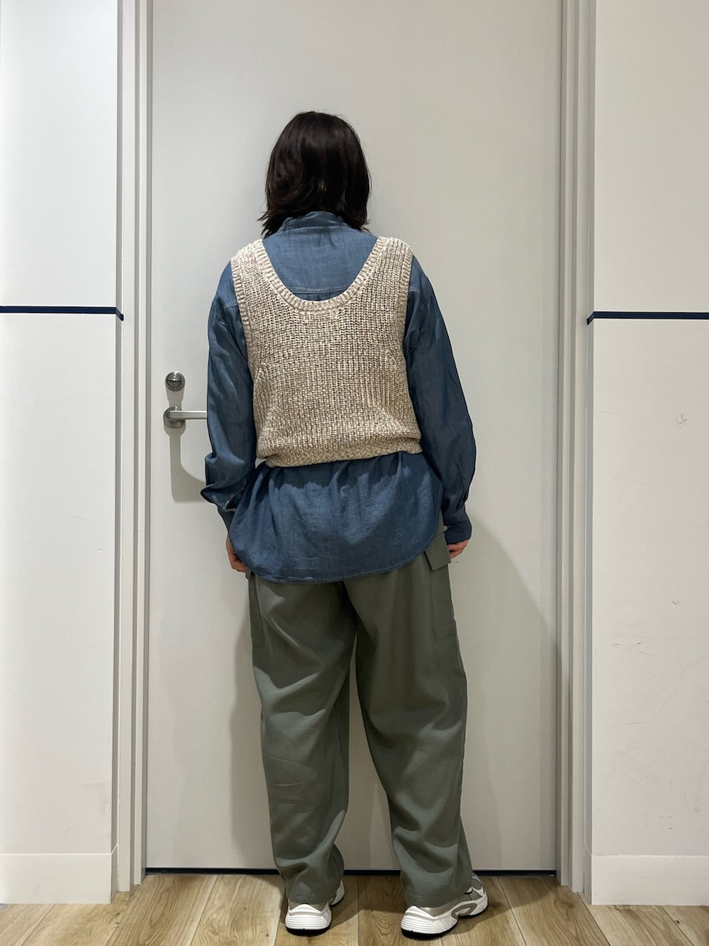 ベージュ系のベスト、ブルー系のシャツ/ブラウス、ブラウン系のトートバッグを着用したレディースの春コーディネートの2枚目の写真