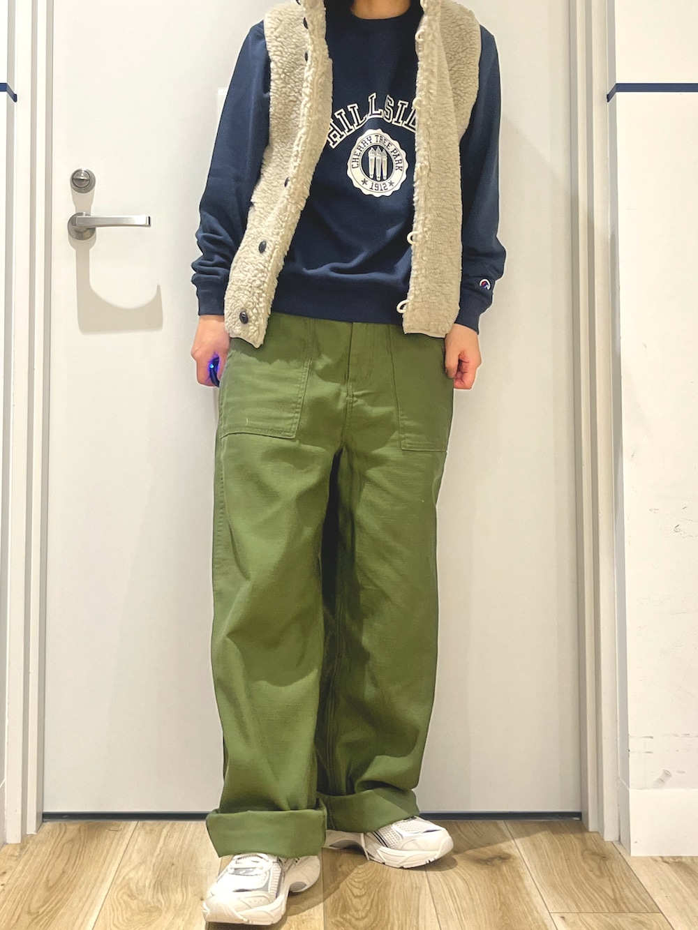 グレー系のスニーカー、グリーン系のその他パンツ、ベージュ系のベストを着用したレディースの秋コーディネートの3枚目の写真