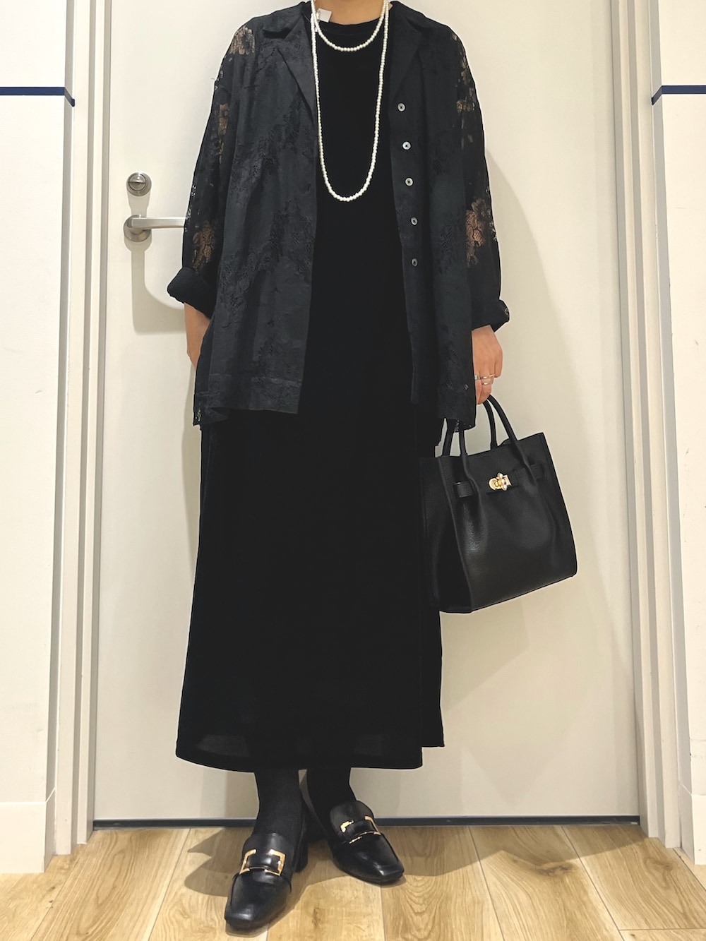 ブラック系のパンプス、ブラック系のハンドバッグ、ブラック系のシャツ/ブラウスを着用したレディースの秋コーディネートの3枚目の写真