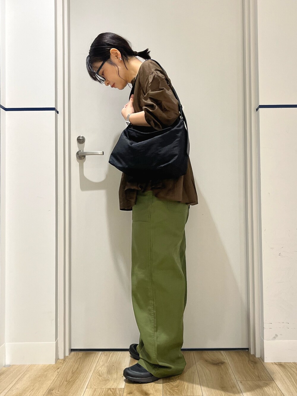 ブラウン系のシャツ/ブラウス、ブラック系のショルダーバッグ、グリーン系のその他パンツを着用したレディースの秋コーディネートの2枚目の写真