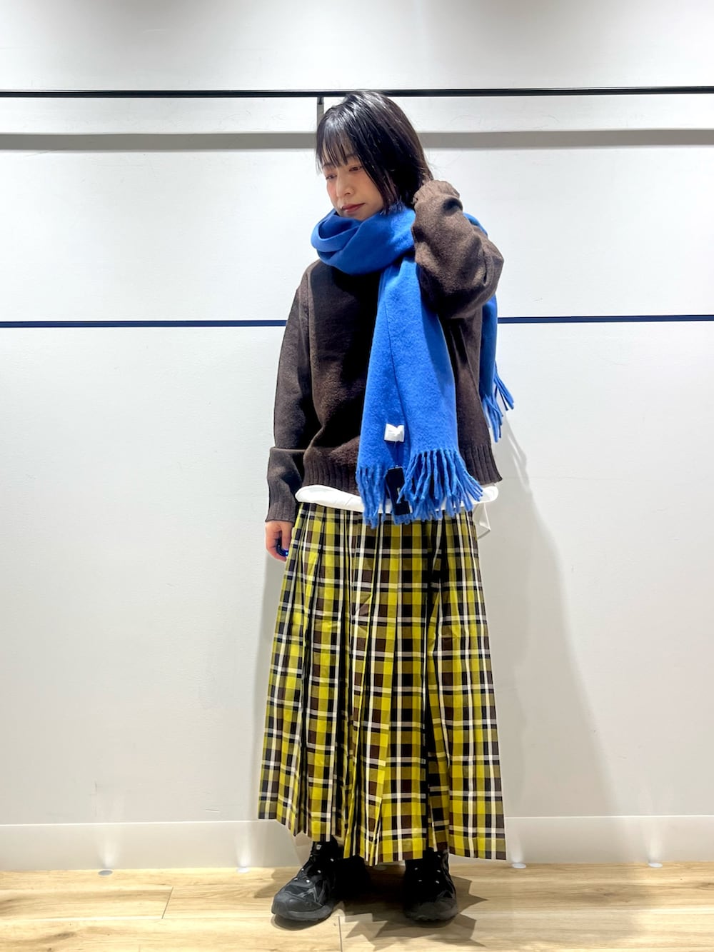 ブラック系のスニーカー、グリーン系のスカート、ホワイト系のシャツ/ブラウスを着用したレディースの冬コーディネートの2枚目の写真