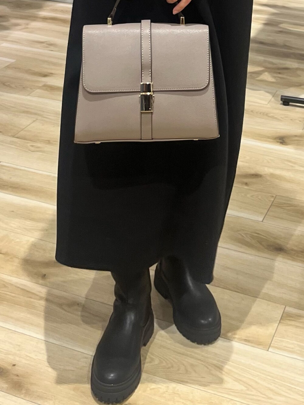 ブラック系のワンピース、グレー系のハンドバッグ、ブラック系のブーツを着用したレディースの秋コーディネートの7枚目の写真