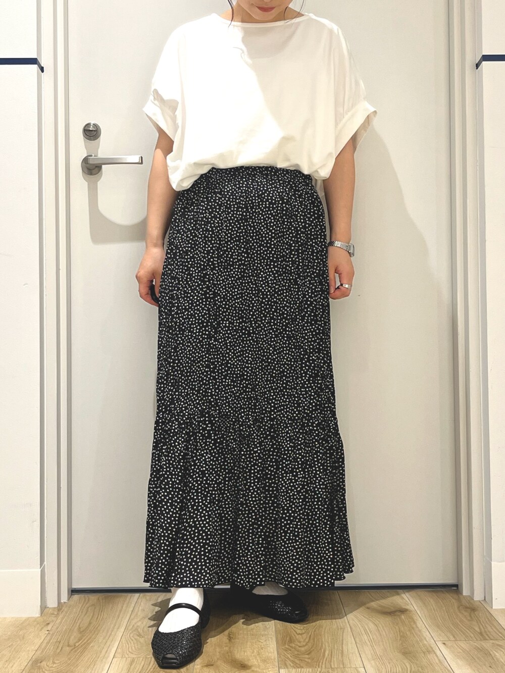 ブラック系のスカート、ブラック系のその他シューズ、ホワイト系のTシャツ/カットソーを着用したレディースの夏コーディネートの5枚目の写真