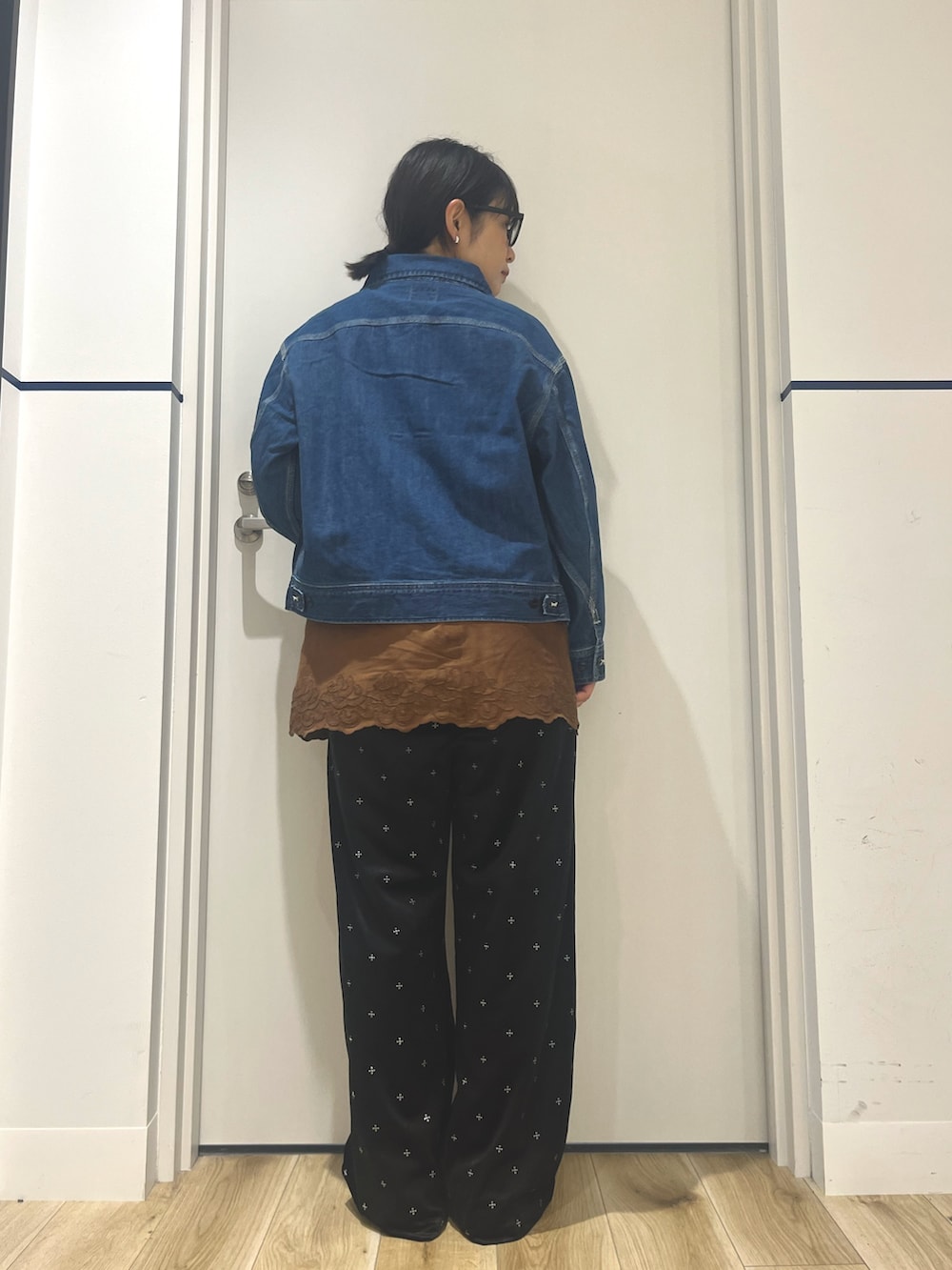 ブラック系のその他パンツ、レッド系のスニーカー、ブルー系のデニムジャケットを着用したレディースの秋コーディネートの3枚目の写真