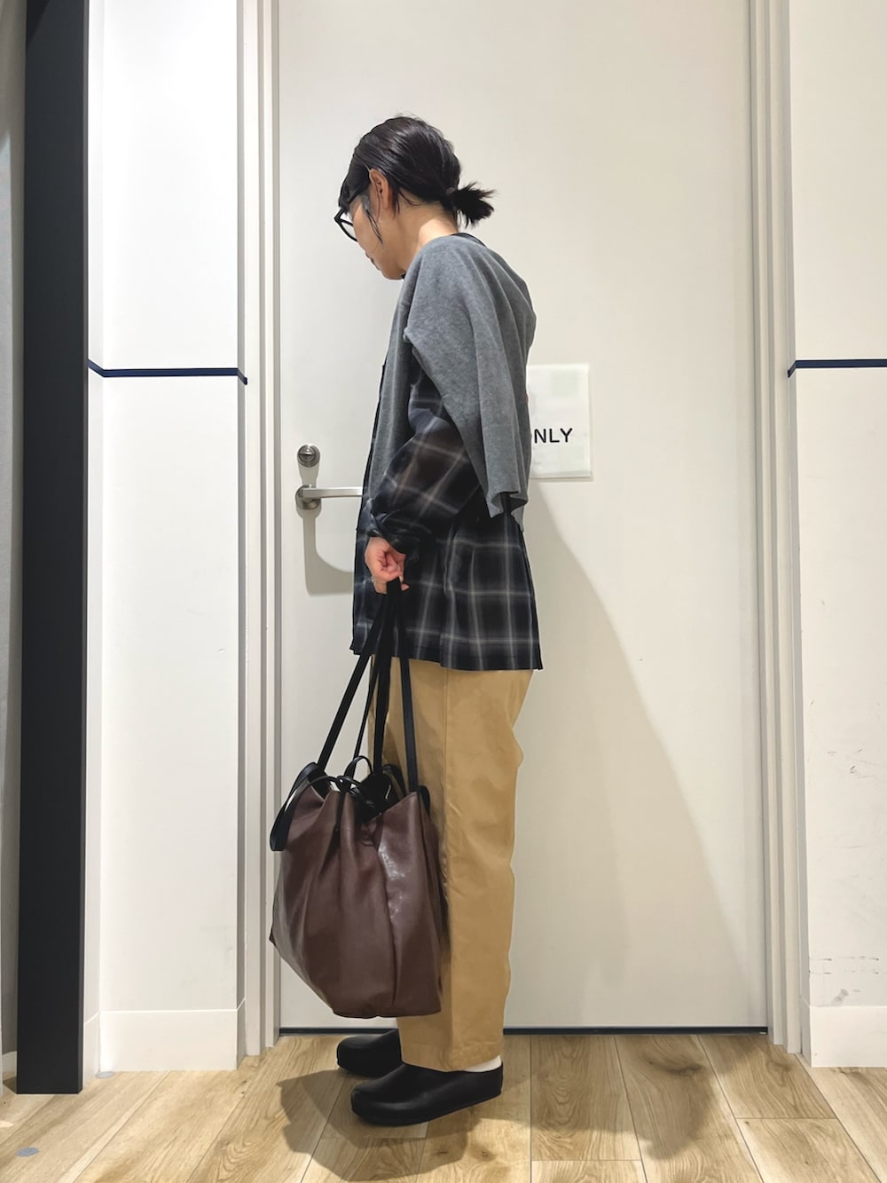 グレー系のカーディガン/ボレロ、ベージュ系のその他パンツ、ブラウン系のトートバッグを着用したレディースの秋コーディネートの2枚目の写真