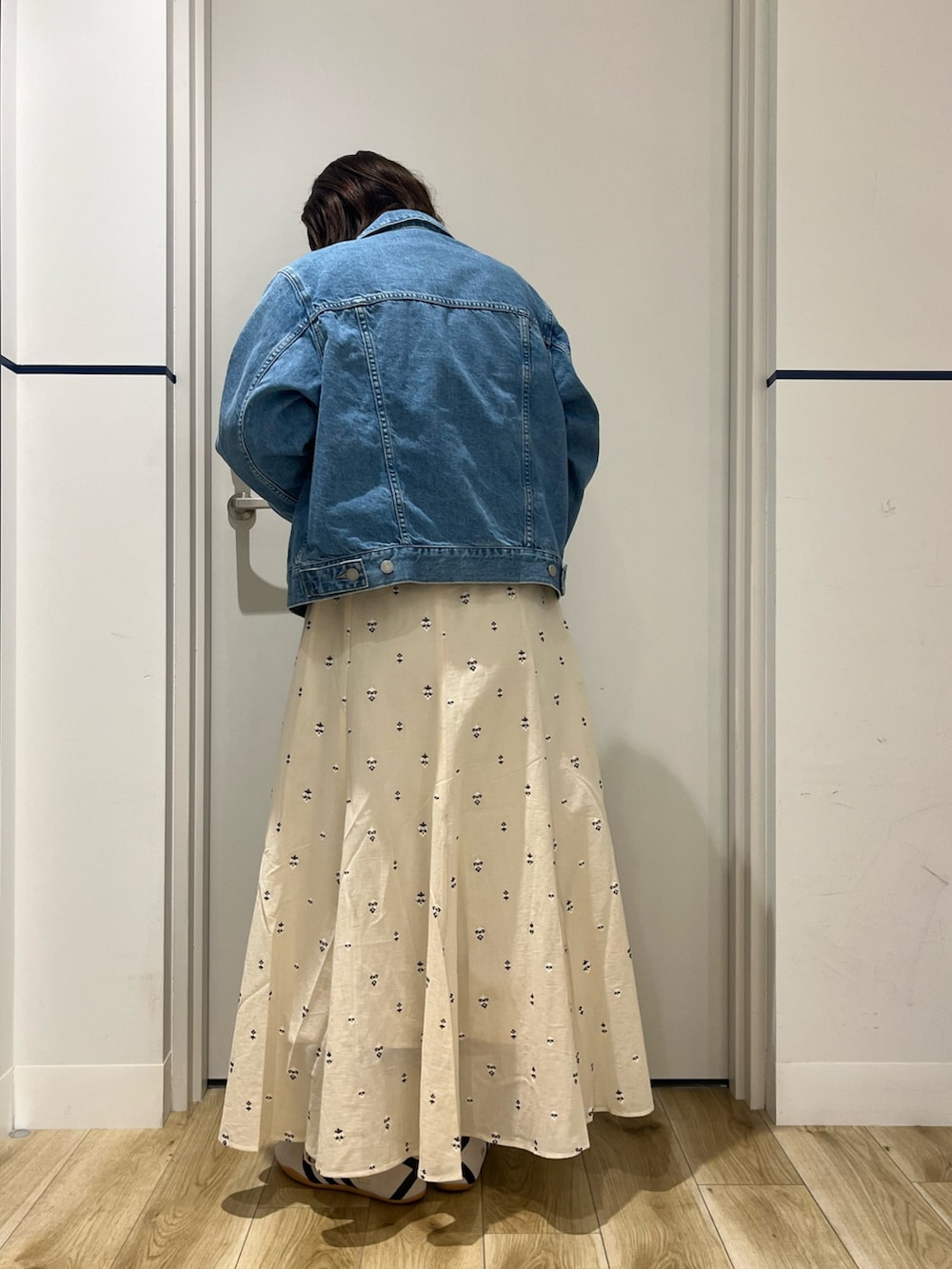 ブラック系のボストンバッグ、ホワイト系のスカート、ホワイト系のスニーカーを着用したレディースの春コーディネートの3枚目の写真