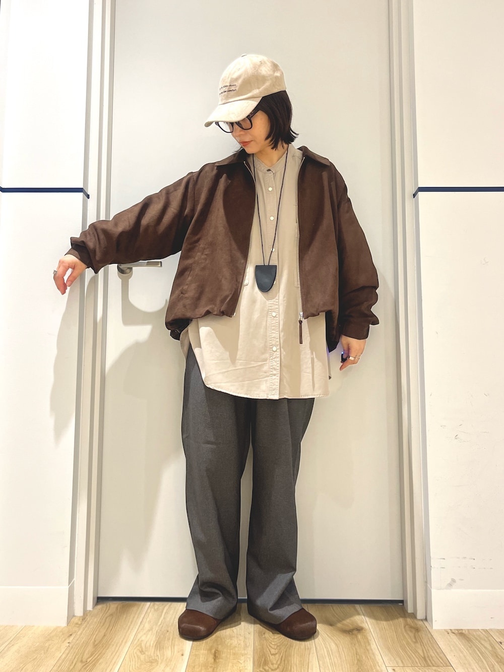 ブラウン系のブルゾン、ブラウン系のその他シューズ、グレー系のその他パンツを着用したレディースの秋コーディネートの2枚目の写真
