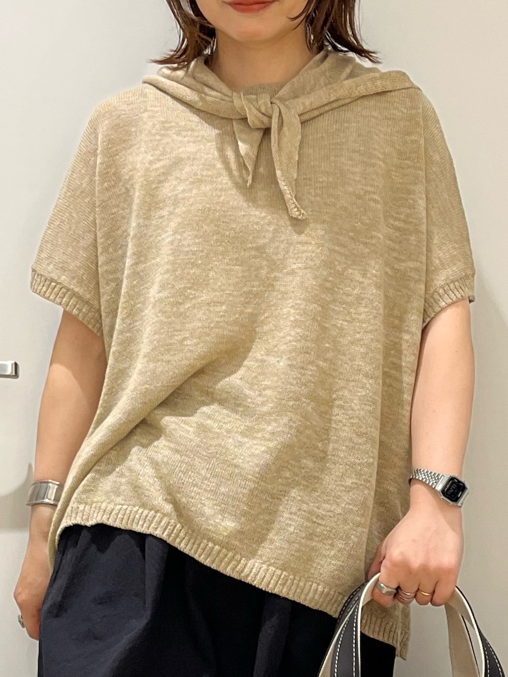 グレー系のトートバッグ、ホワイト系のサンダル、ブラック系のその他パンツを着用したレディースの春コーディネートの4枚目の写真