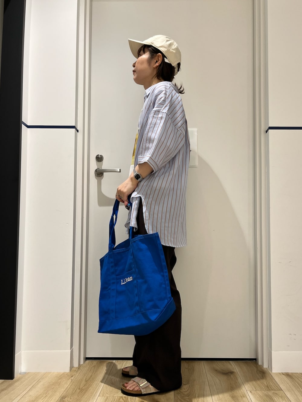 ブラウン系のその他パンツ、ベージュ系のサンダル、ブルー系のトートバッグを着用したレディースの夏コーディネートの2枚目の写真