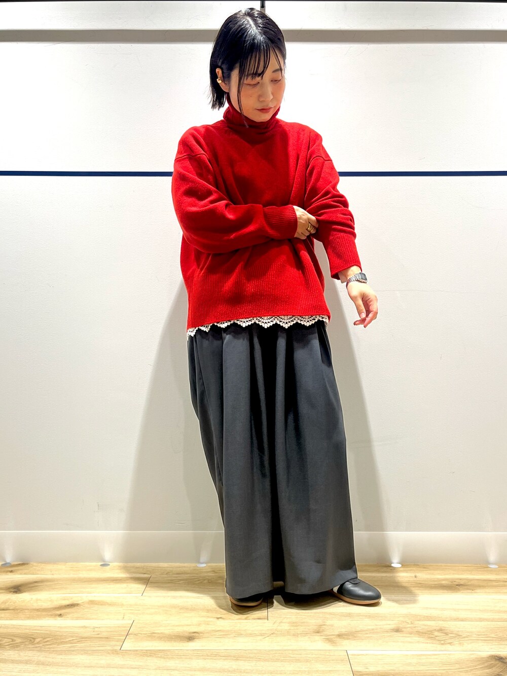 レッド系のニット/セーター、ブラック系のステンカラーコート、ホワイト系のTシャツ/カットソーを着用したレディースの冬コーディネートの9枚目の写真