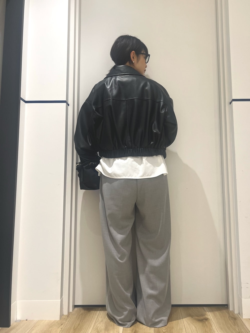 ブラック系のトートバッグ、ブラック系のブルゾン、ホワイト系のシャツ/ブラウスを着用したレディースの秋コーディネートの3枚目の写真