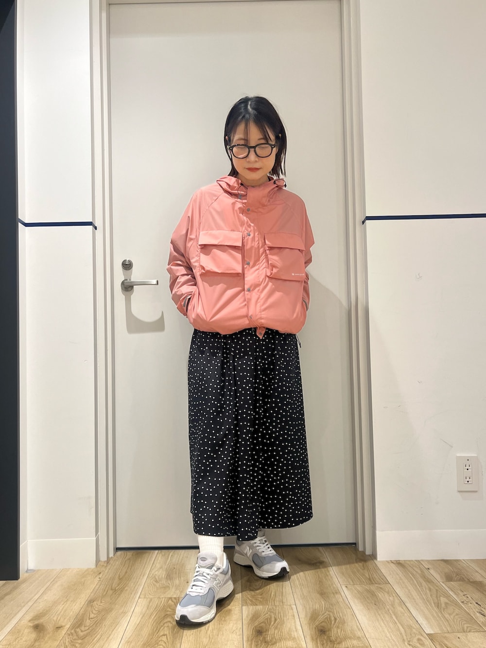 ベージュ系のスニーカー、ブラック系のワンピース、ピンク系のナイロンジャケットを着用したレディースの冬コーディネートの3枚目の写真