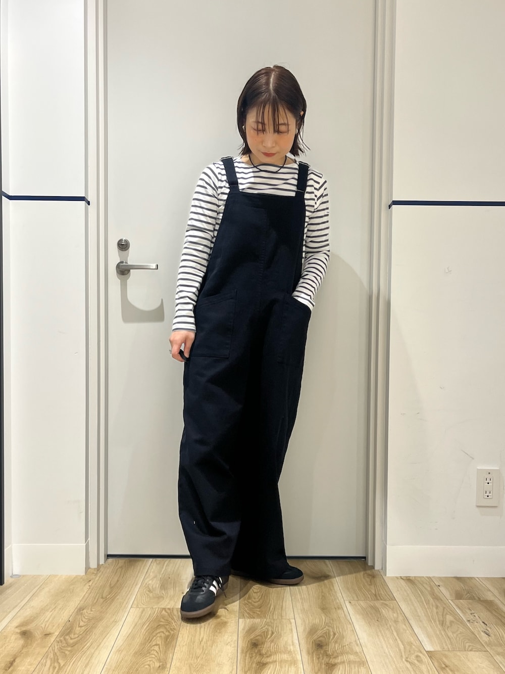 ホワイト系のTシャツ/カットソー、ブラック系のサロペット/オーバーオール、ホワイト系のハンドバッグを着用したレディースの春コーディネートの5枚目の写真