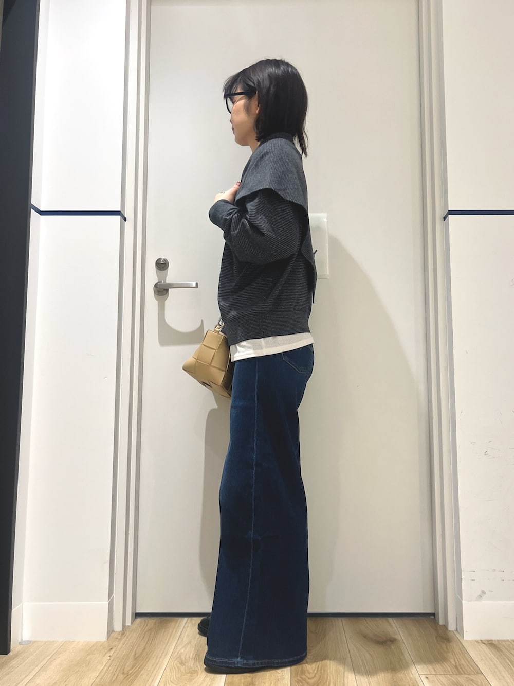 ブラック系のローファー、ブルー系のデニムパンツ、ブラック系のニット/セーターを着用したレディースの秋コーディネートの2枚目の写真