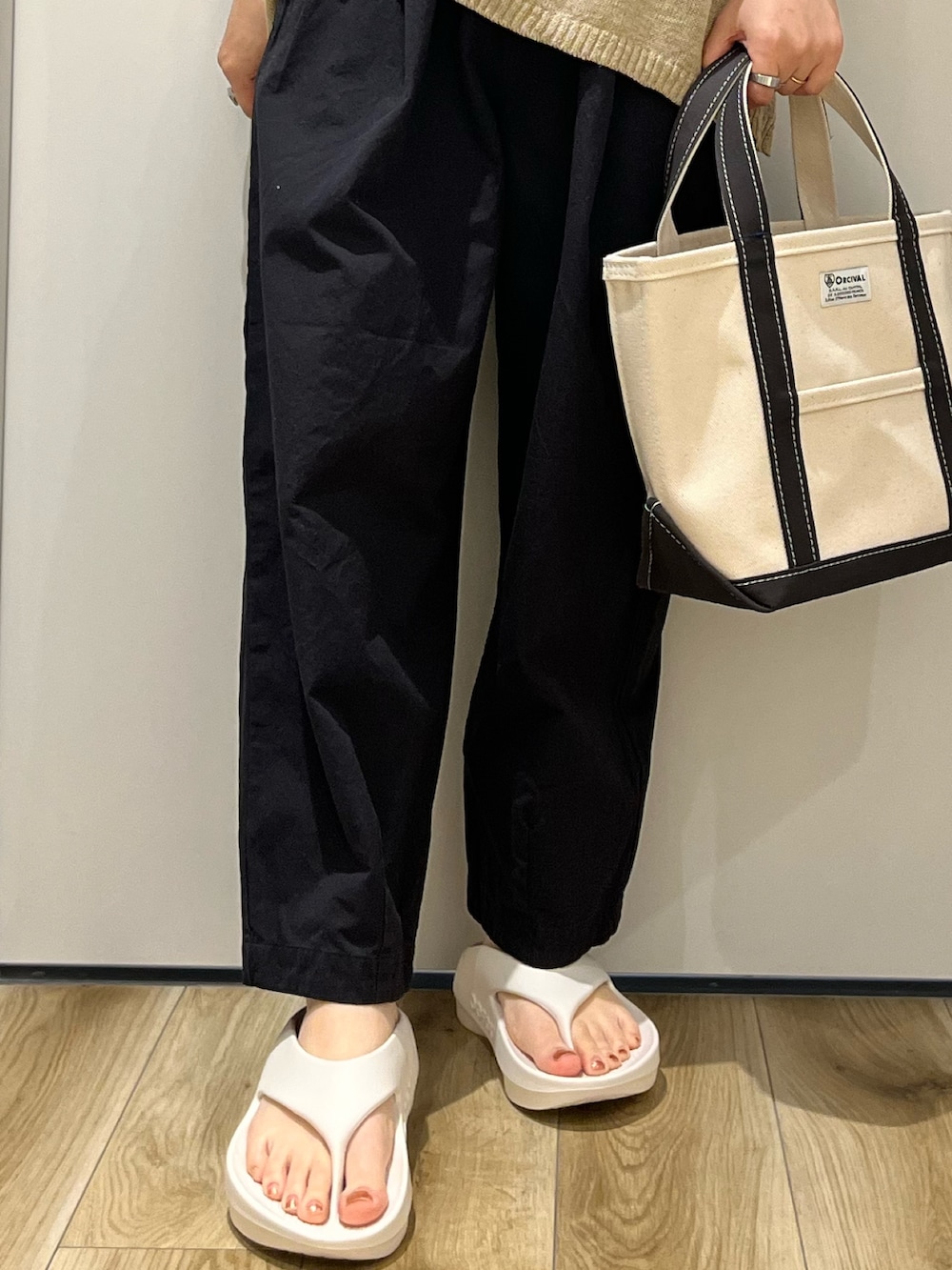 グレー系のトートバッグ、ホワイト系のサンダル、ブラック系のその他パンツを着用したレディースの春コーディネートの5枚目の写真