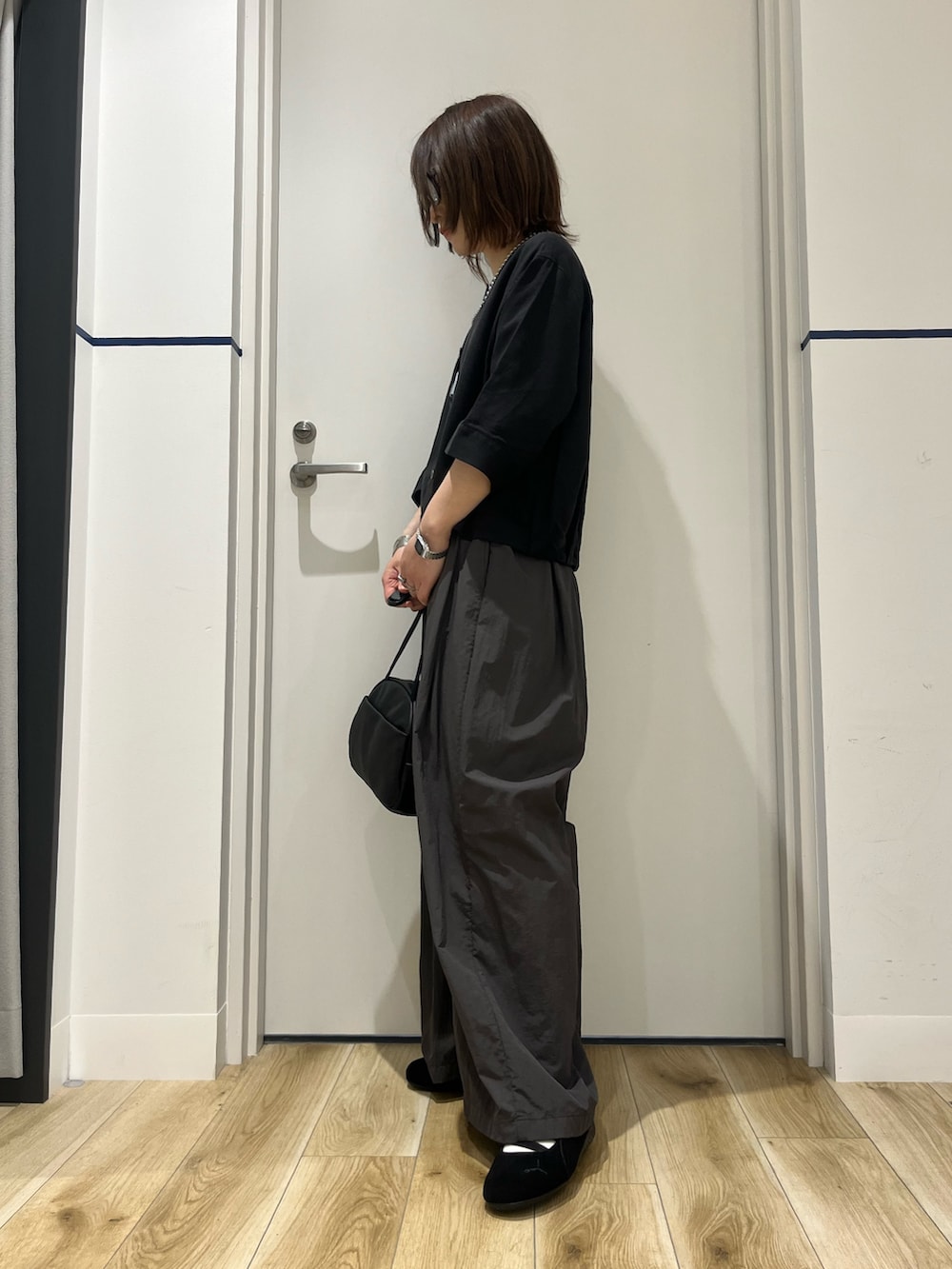 ブラック系のボストンバッグ、ブラック系のシャツ/ブラウス、グレー系のその他パンツを着用したレディースの春コーディネートの2枚目の写真