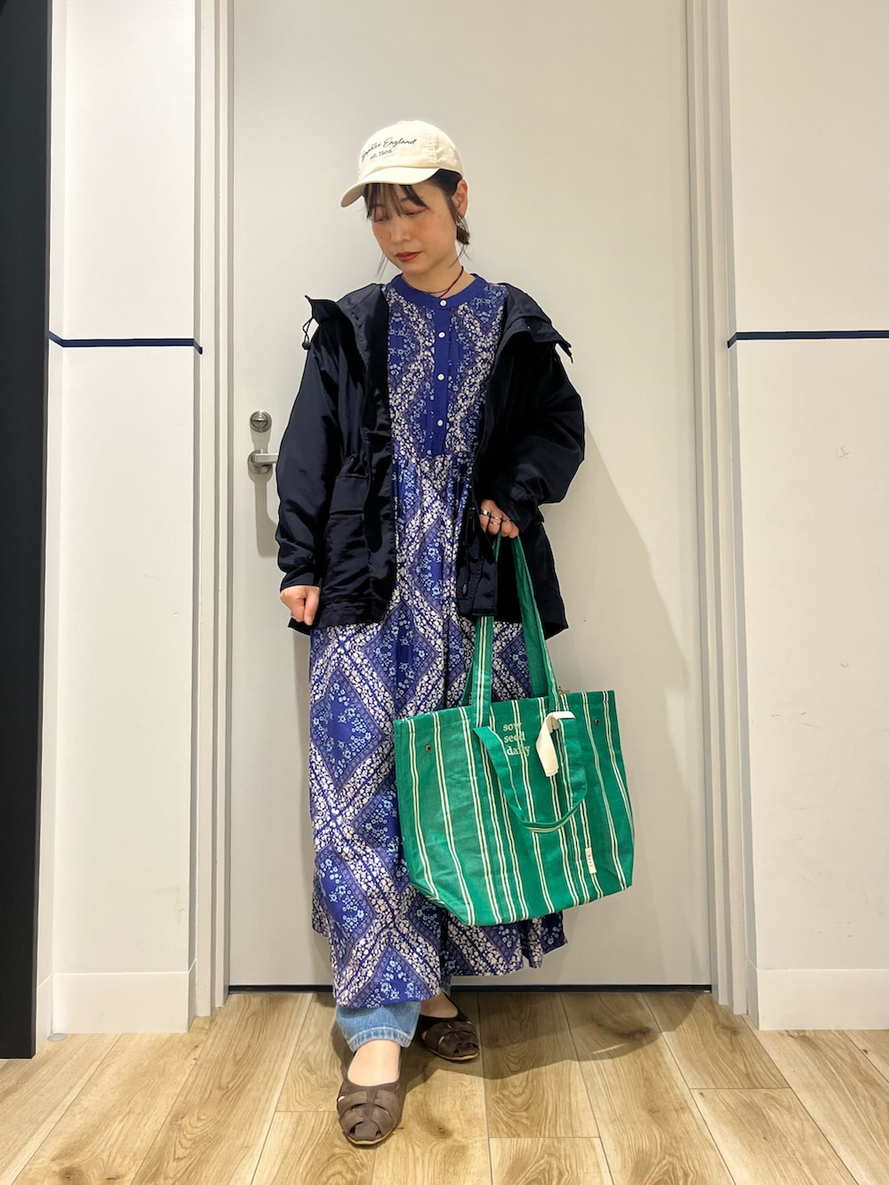 ブルー系のデニムパンツ、ブルー系のワンピース、ブラウン系のパンプスを着用したレディースの春コーディネートの2枚目の写真