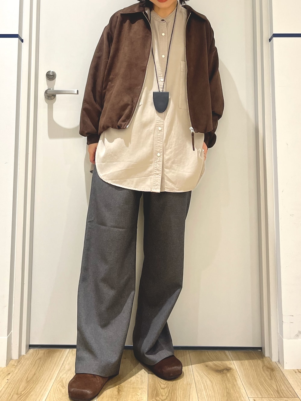 ブラウン系のブルゾン、ブラウン系のその他シューズ、グレー系のその他パンツを着用したレディースの秋コーディネートの5枚目の写真