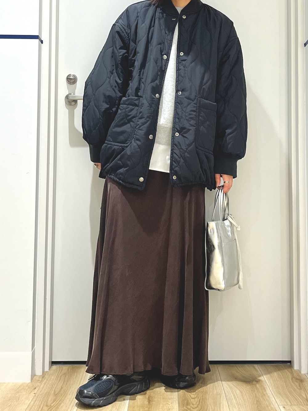 ホワイト系のTシャツ/カットソー、グレー系のニット/セーター、ブラック系のブルゾンを着用したレディースの秋コーディネートの4枚目の写真