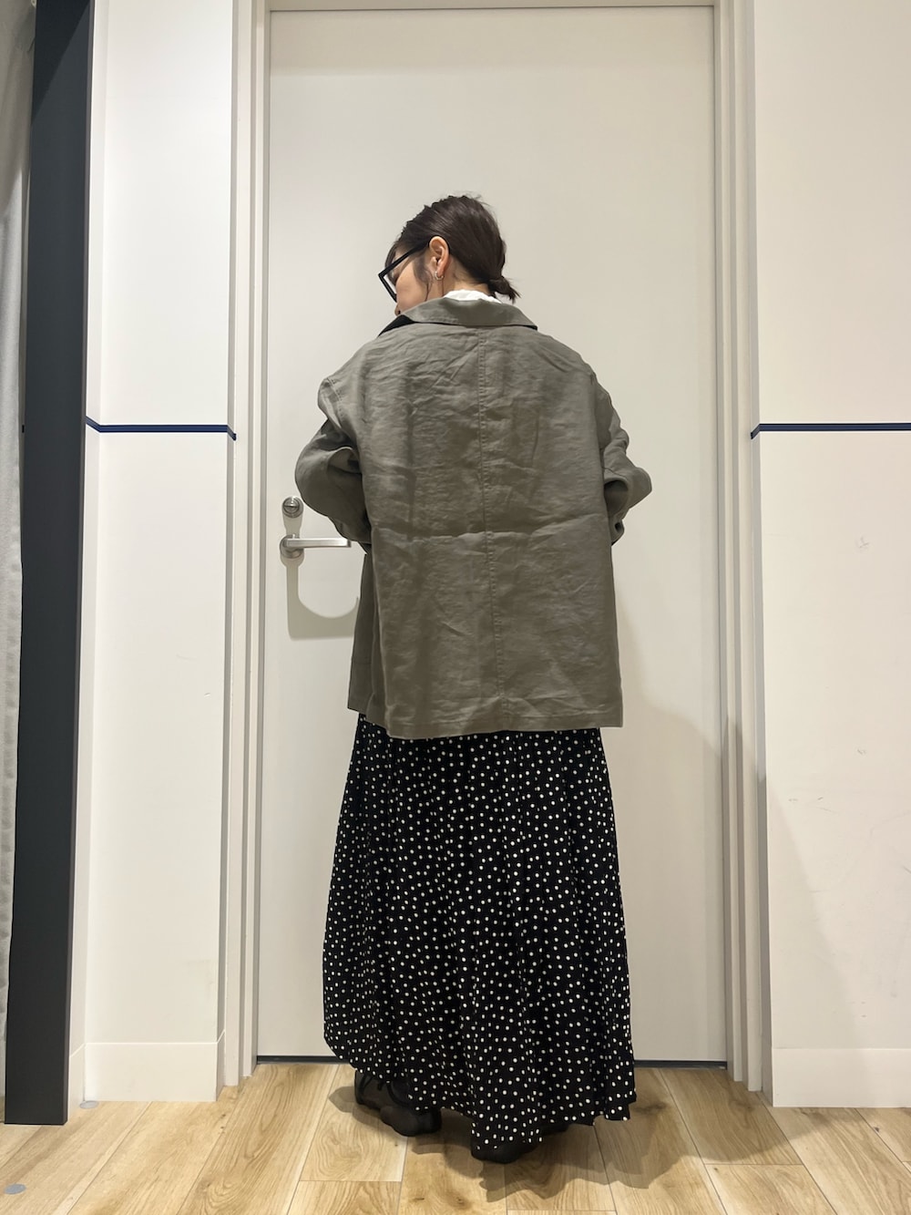 ブラック系のスニーカー、ブラック系のスカート、グレー系のカバーオールを着用したレディースの春コーディネートの3枚目の写真