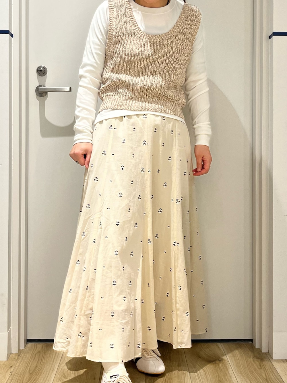 ブラック系のボストンバッグ、ホワイト系のスカート、ホワイト系のスニーカーを着用したレディースの春コーディネートの5枚目の写真