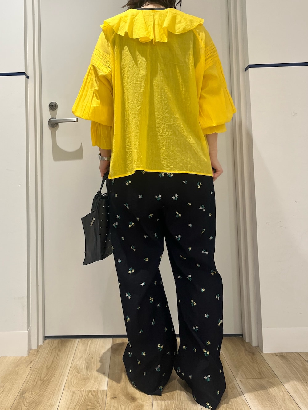 ブラック系のトートバッグ、ブルー系のその他パンツ、ホワイト系のパンプスを着用したレディースの春コーディネートの3枚目の写真