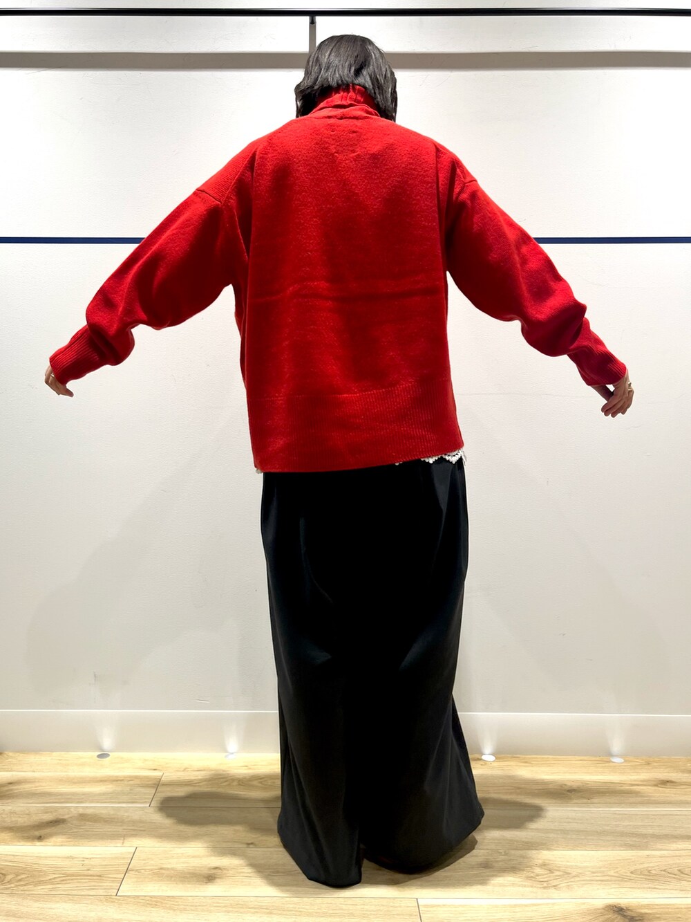 レッド系のニット/セーター、ブラック系のステンカラーコート、ホワイト系のTシャツ/カットソーを着用したレディースの冬コーディネートの8枚目の写真