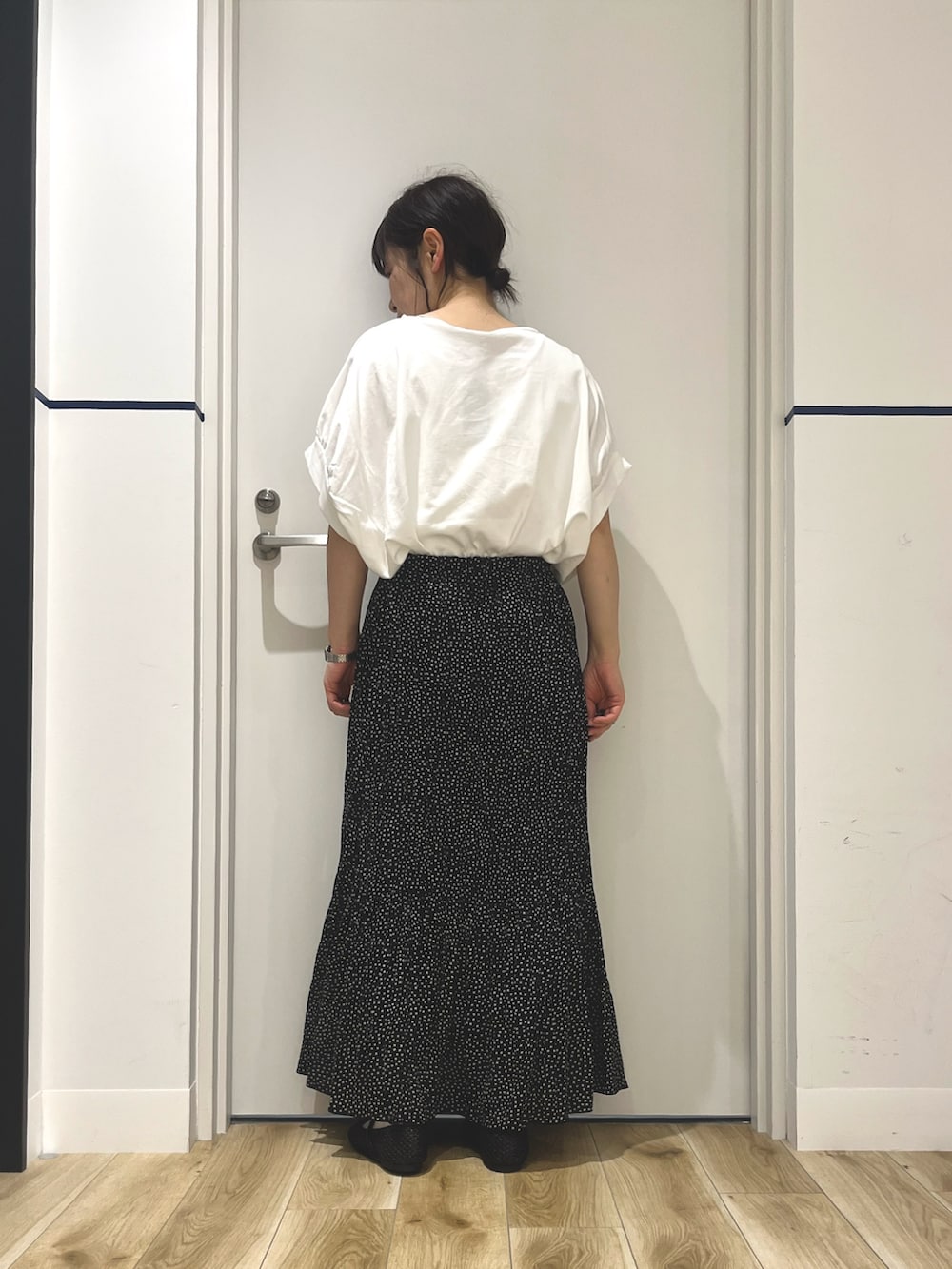 ブラック系のスカート、ブラック系のその他シューズ、ホワイト系のTシャツ/カットソーを着用したレディースの夏コーディネートの2枚目の写真
