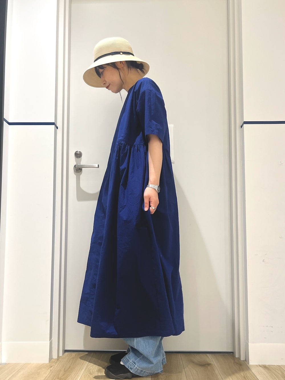 ブルー系のワンピース、ブルー系のトートバッグ、ブルー系のデニムパンツを着用したレディースの夏コーディネートの2枚目の写真