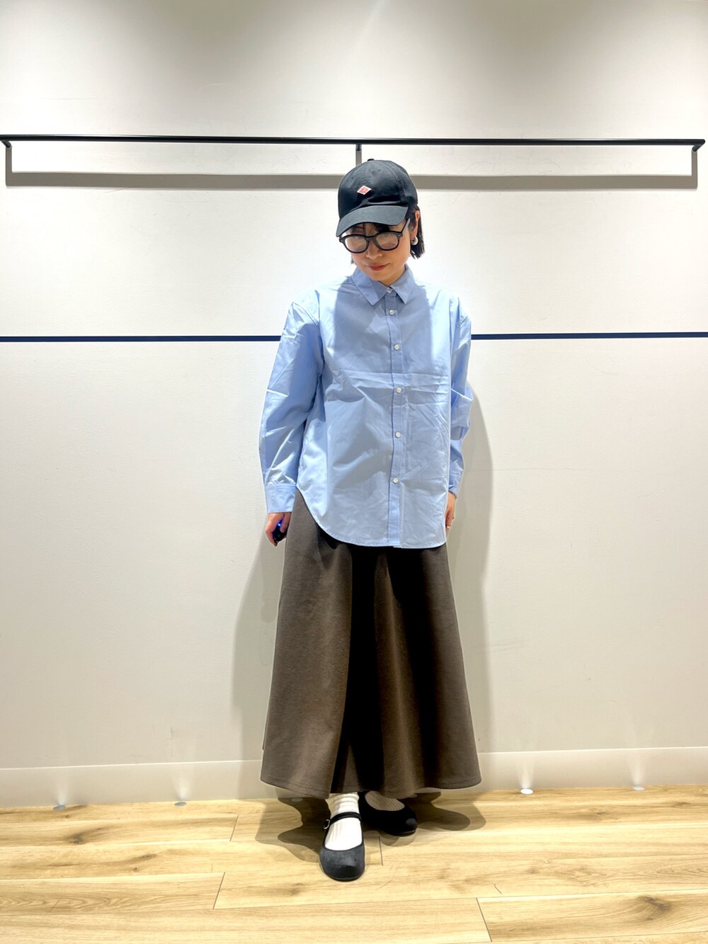 ブルー系のシャツ/ブラウス、グリーン系のチェスターコート、ブラウン系のスカートを着用したレディースの冬コーディネートの6枚目の写真